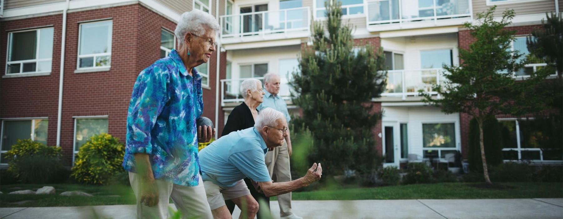 a group of people playing with a ball in front of a building
